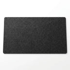 Sous-main de bureau en feutre de laine noir 90x40 cm avec clavier mécanique et souris dans un setup minimaliste.